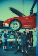 a group of men working on a car in a garage