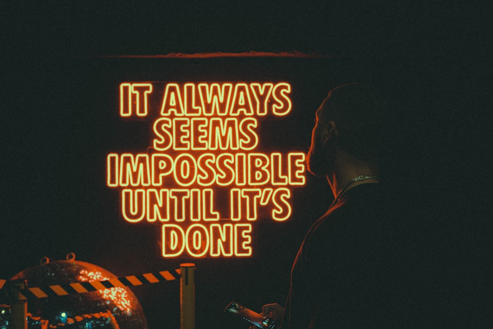 a neon sign that says it always seems impossible until it's done
