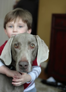 An adorable AI robotic dog sitting next to a smiling child indoors