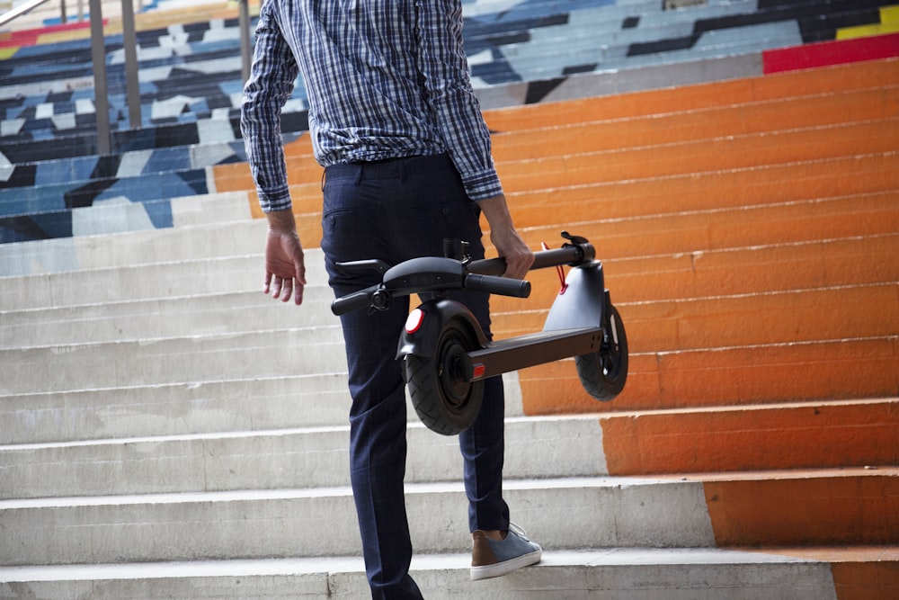 a man walking up a flight of stairs with a bike attached to it