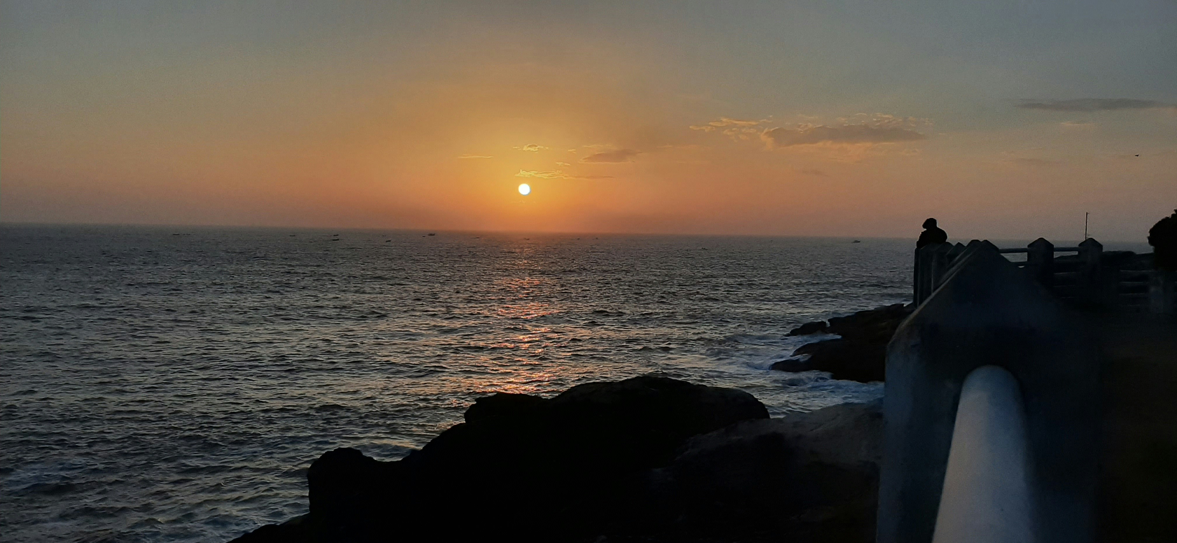 저녁 산책이 숙면에 도움이 되는 이유 - the sun is setting over the ocean as people watch