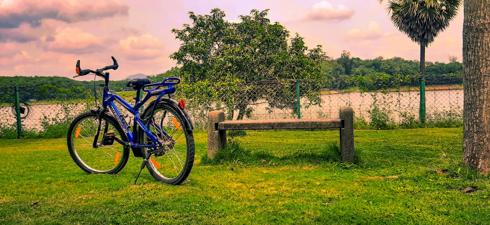 a blue bike parked next to a wooden bench