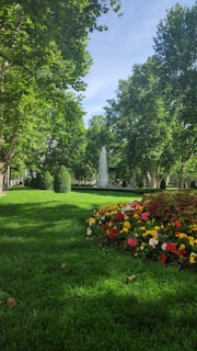 A vibrant public park in southern Spain with lush greenery and colorful flower beds.