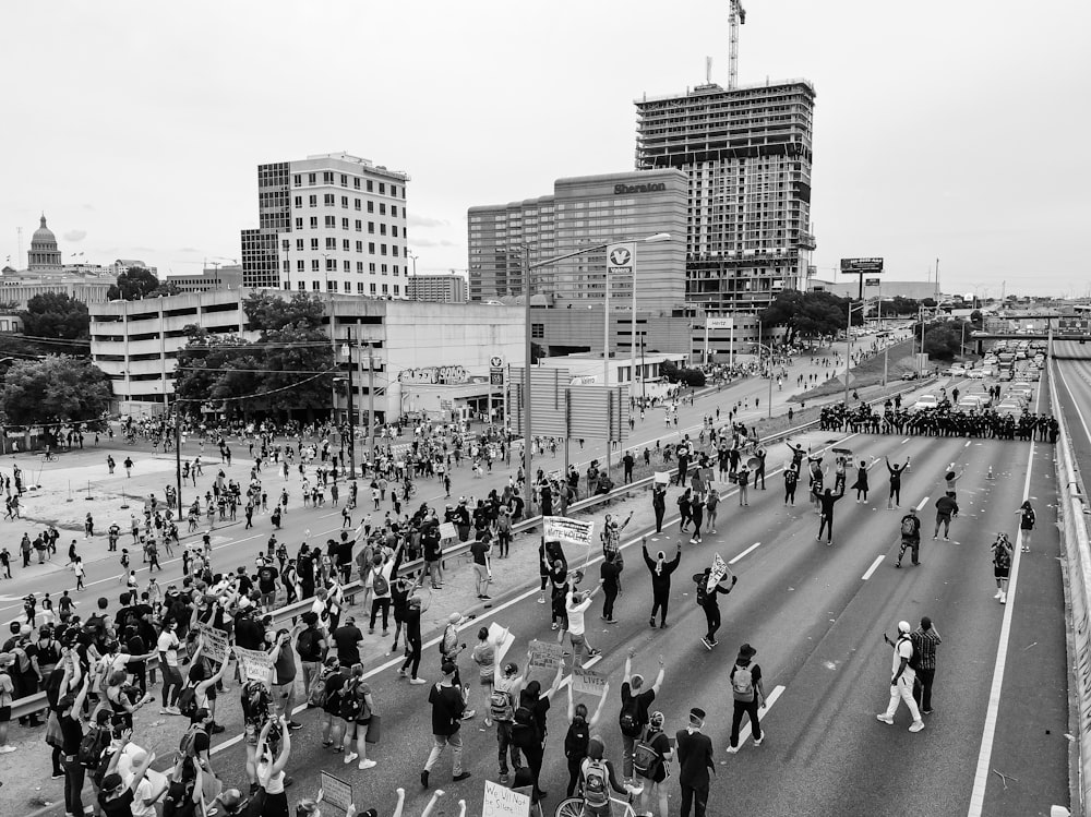 a large group of people walking across a street