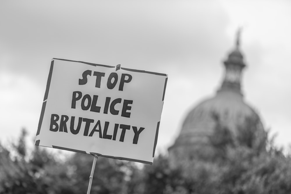 a black and white photo of a sign in front of a building