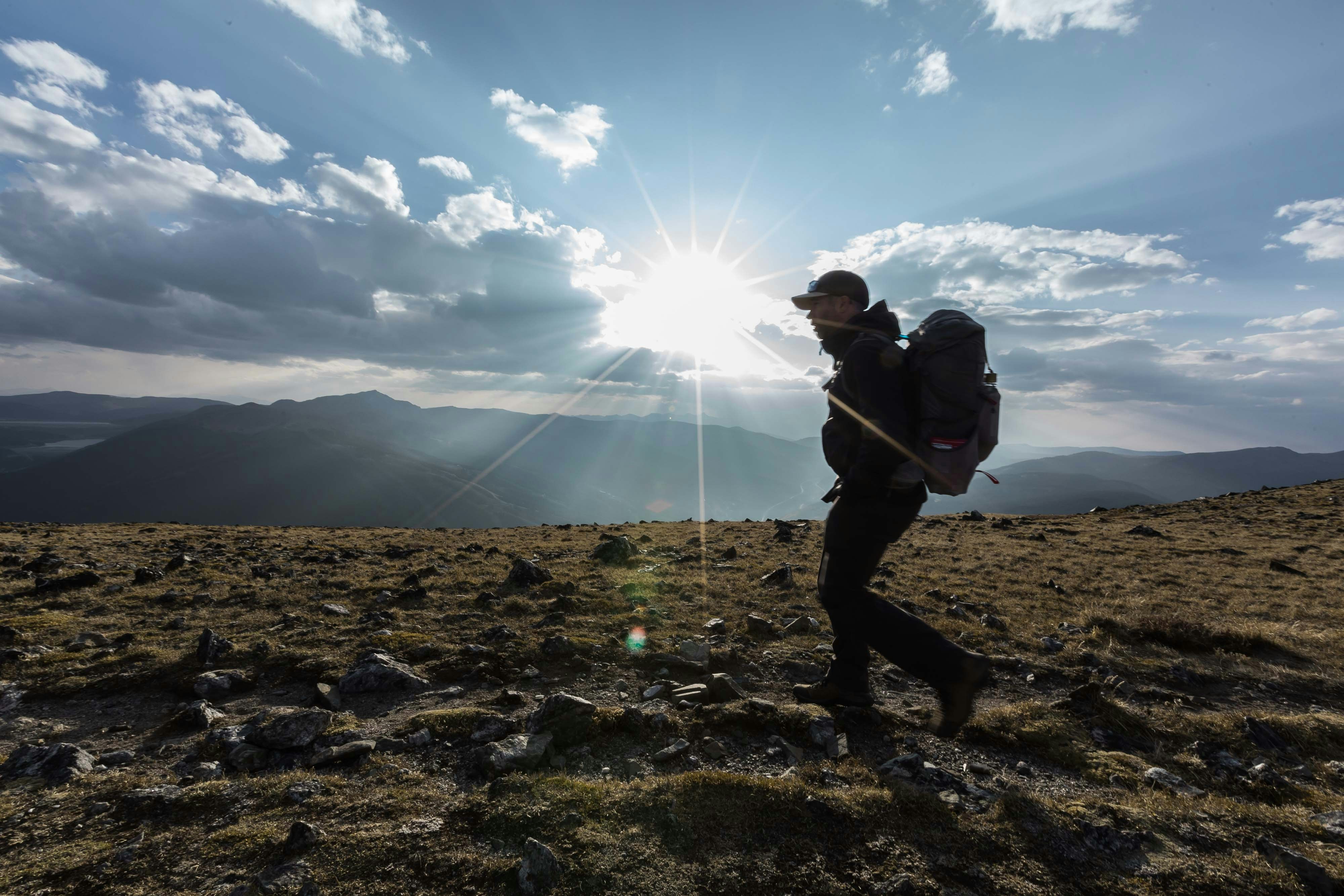 a man with a backpack walking across a field