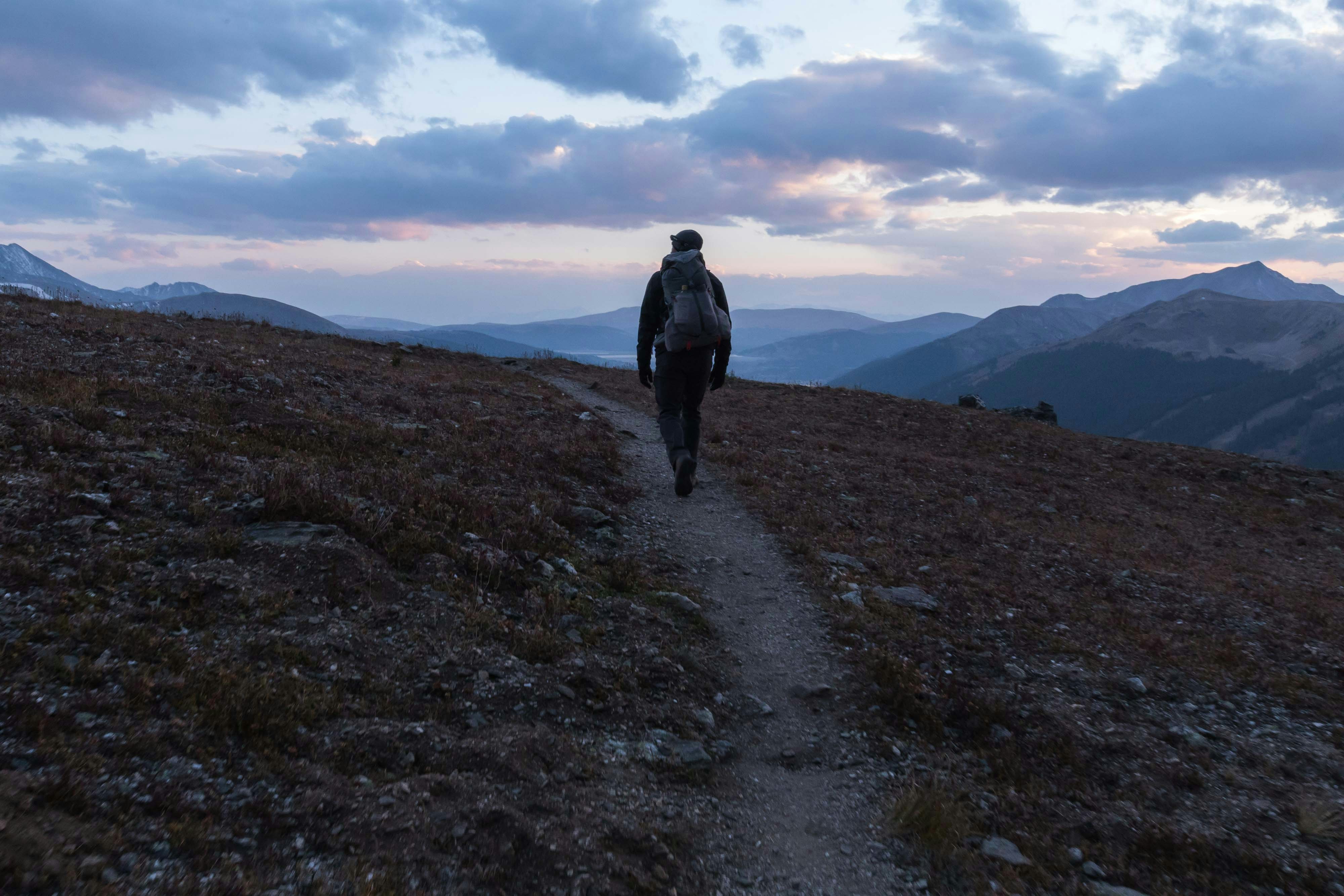 a person walking up a hill with a backpack