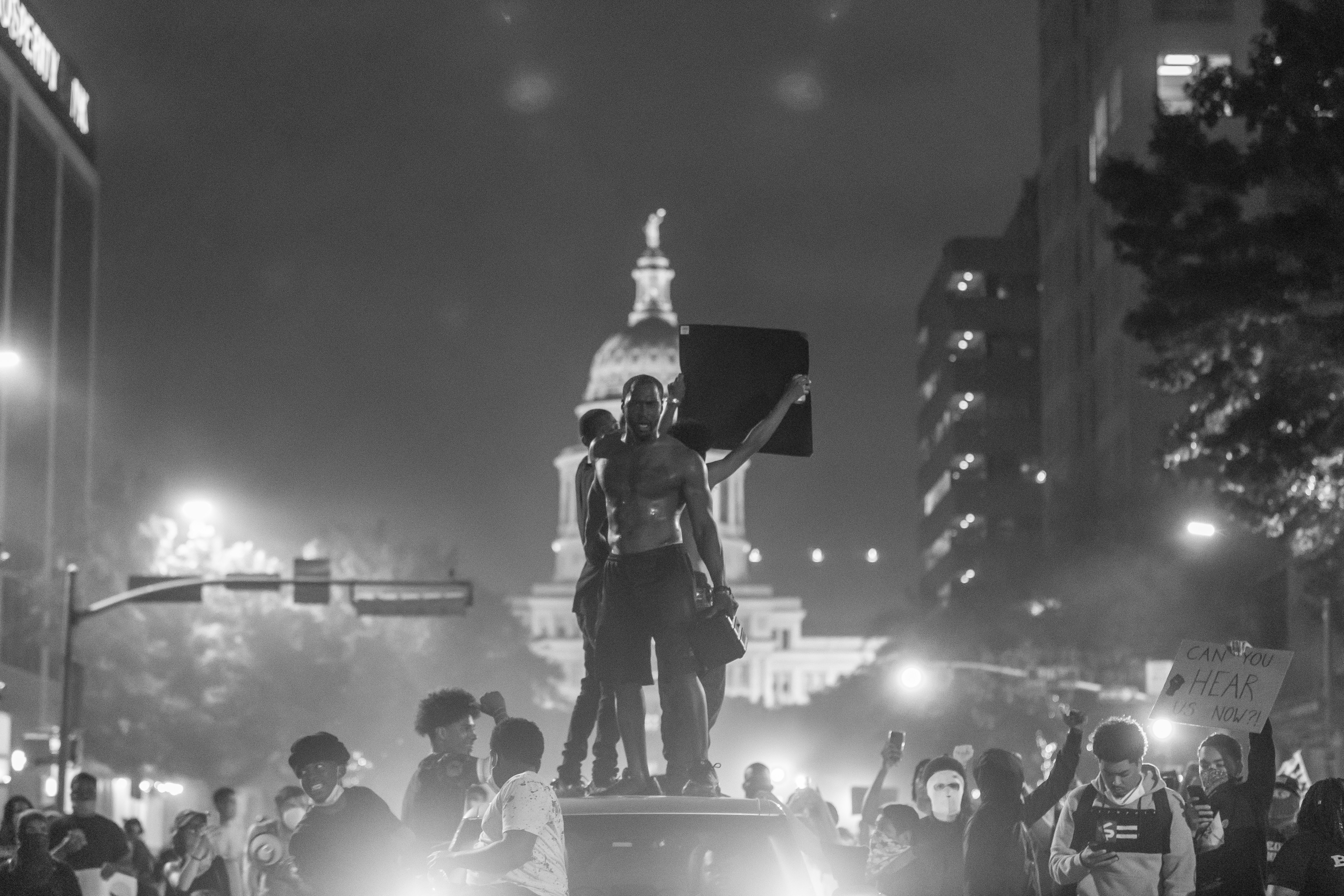 a group of people standing on top of a car