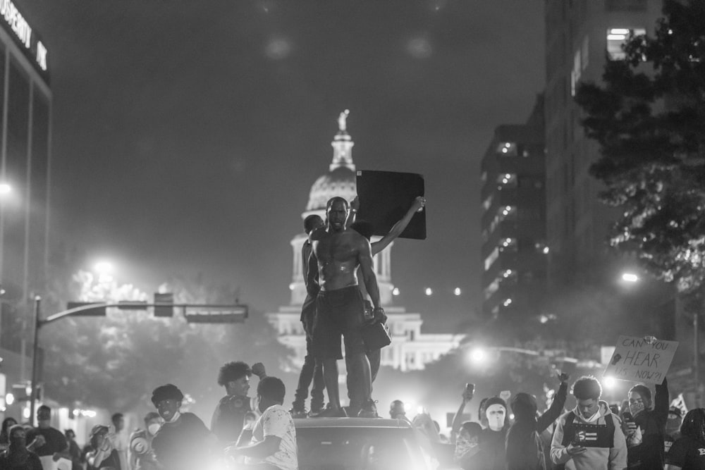 a group of people standing on top of a car