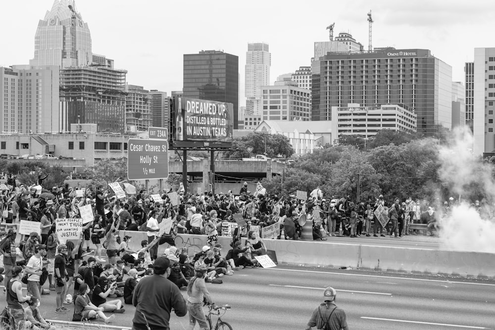 a large group of people standing on the side of a road