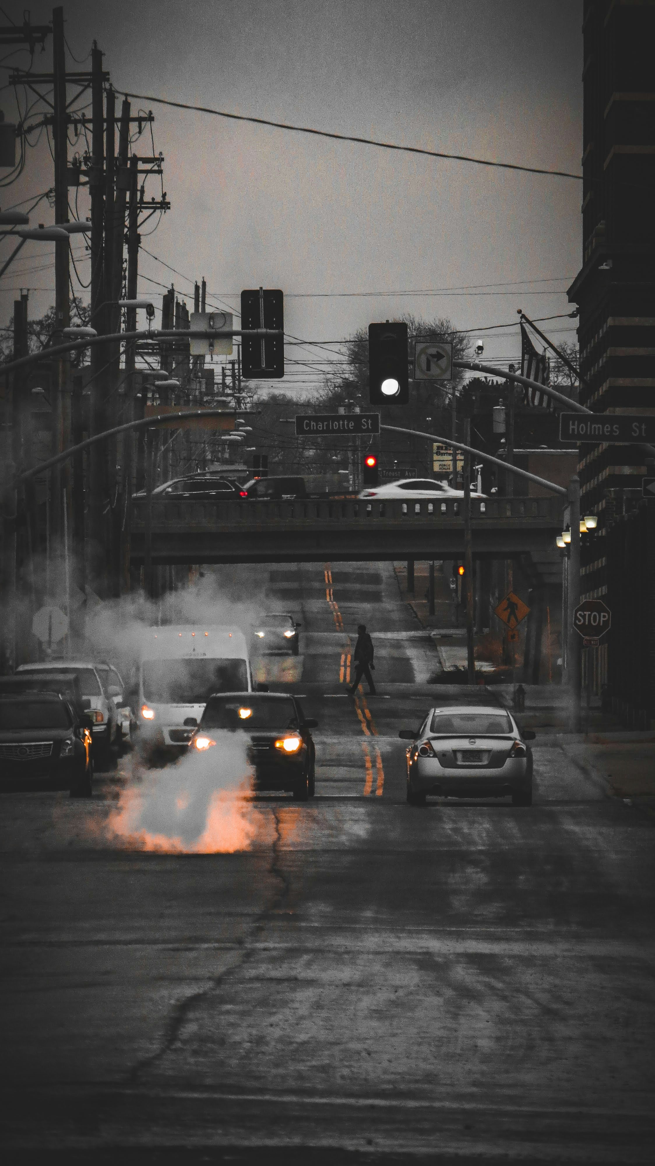 a group of cars driving down a street next to a traffic light