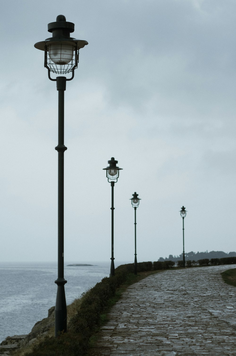 a cobblestone path leading to a light pole