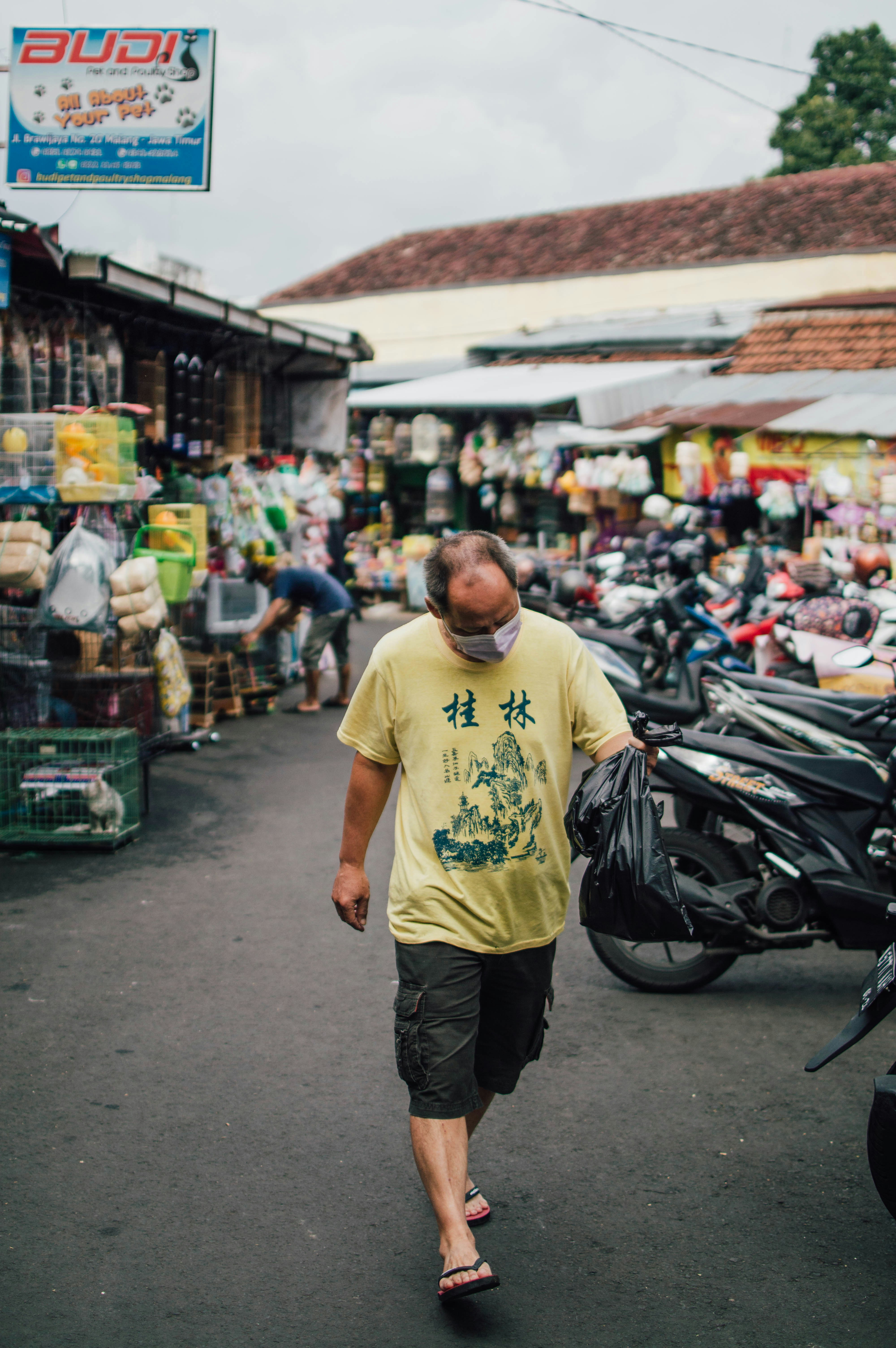 a man walking down a street in front of a store