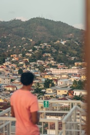 a person standing on a balcony looking at a city