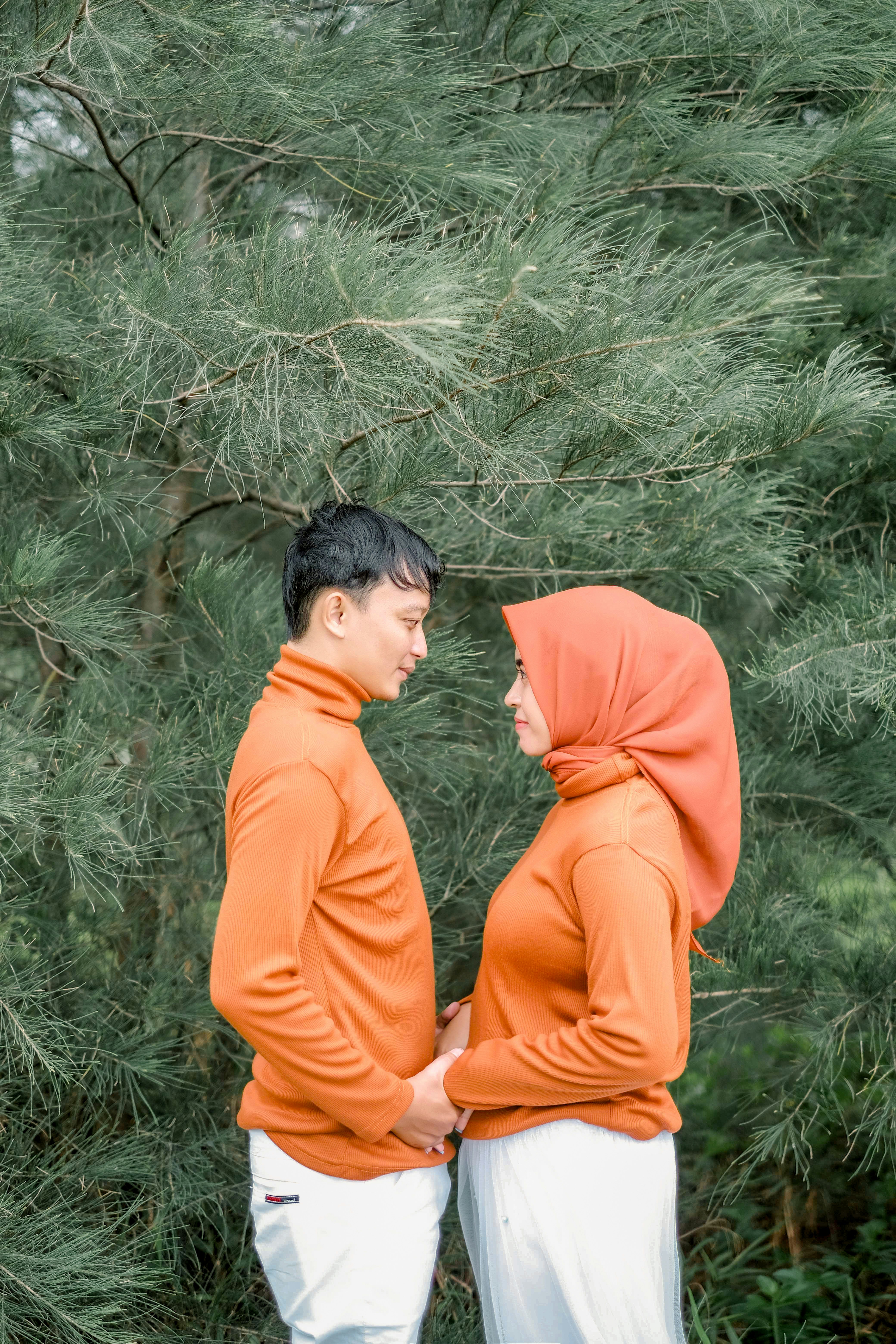 seorang pria dan seorang wanita berdiri di depan pohon
