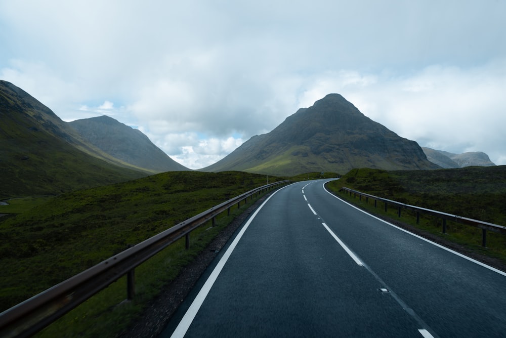 an empty road with mountains in the background