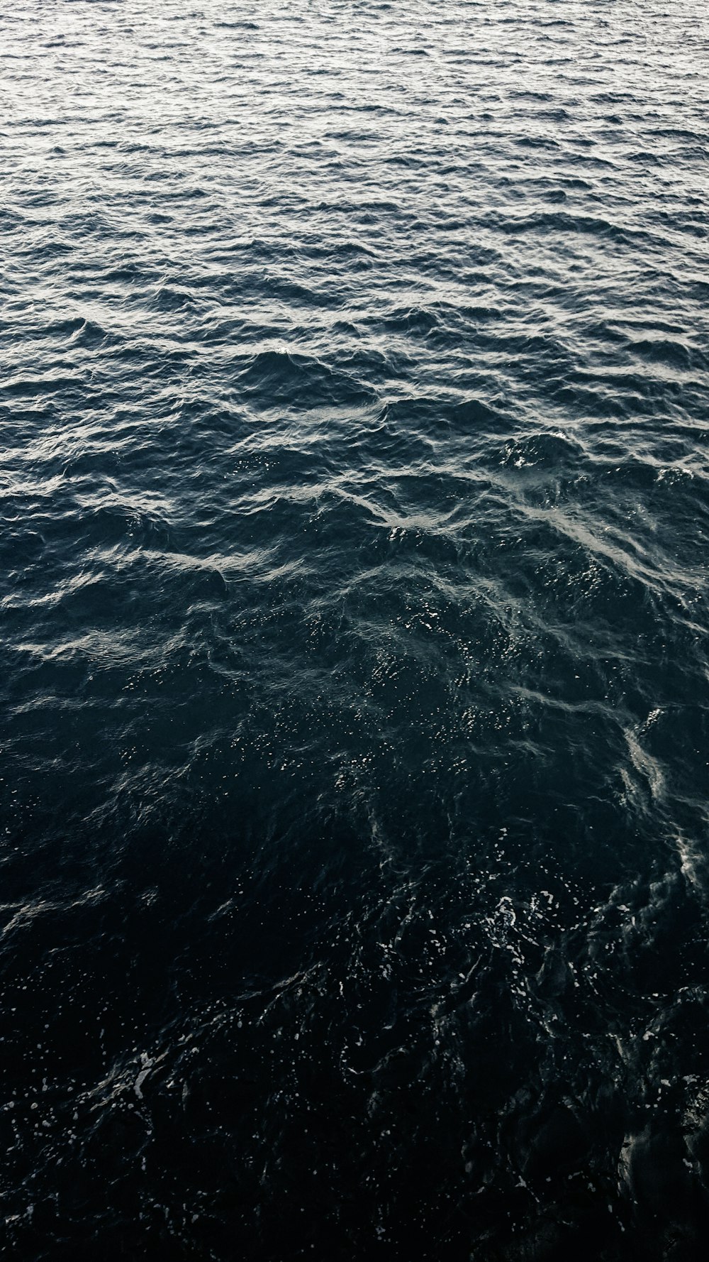 a large body of water with a boat in the distance