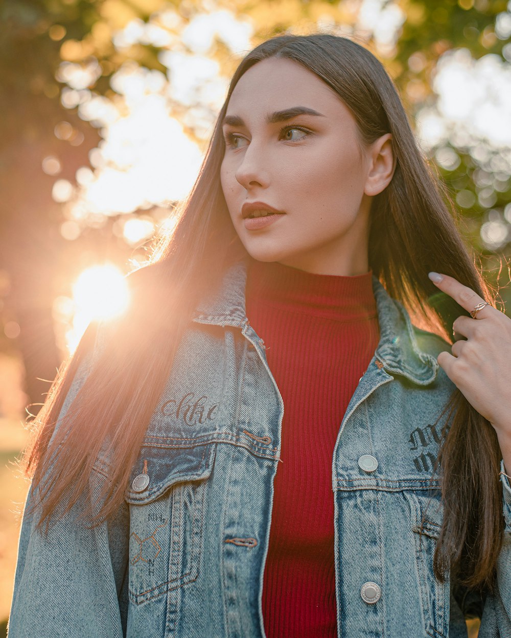 Una mujer con camisa roja y chaqueta de jean