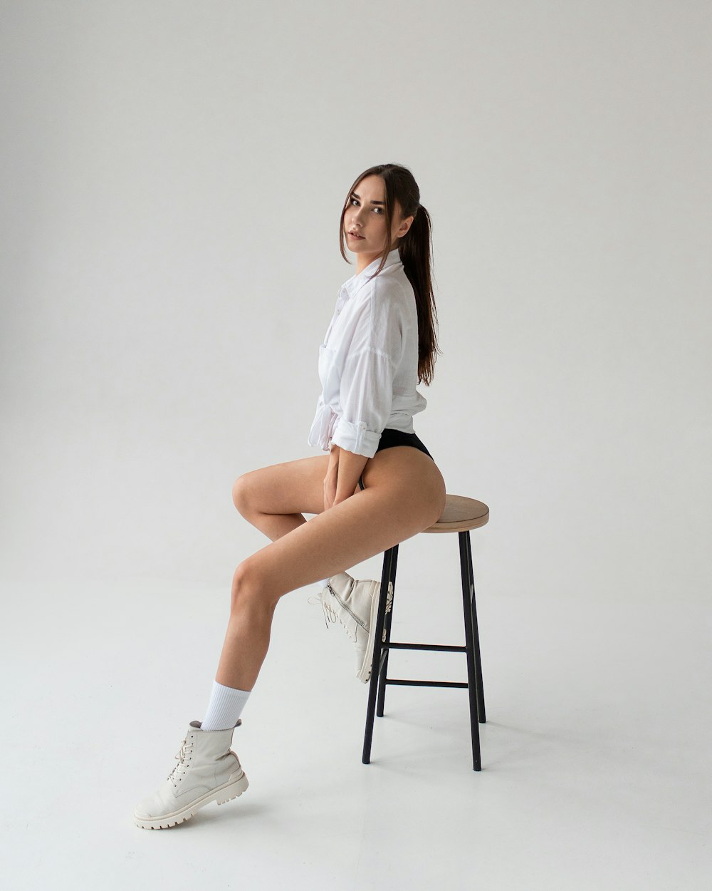 a woman sitting on a stool posing for a picture