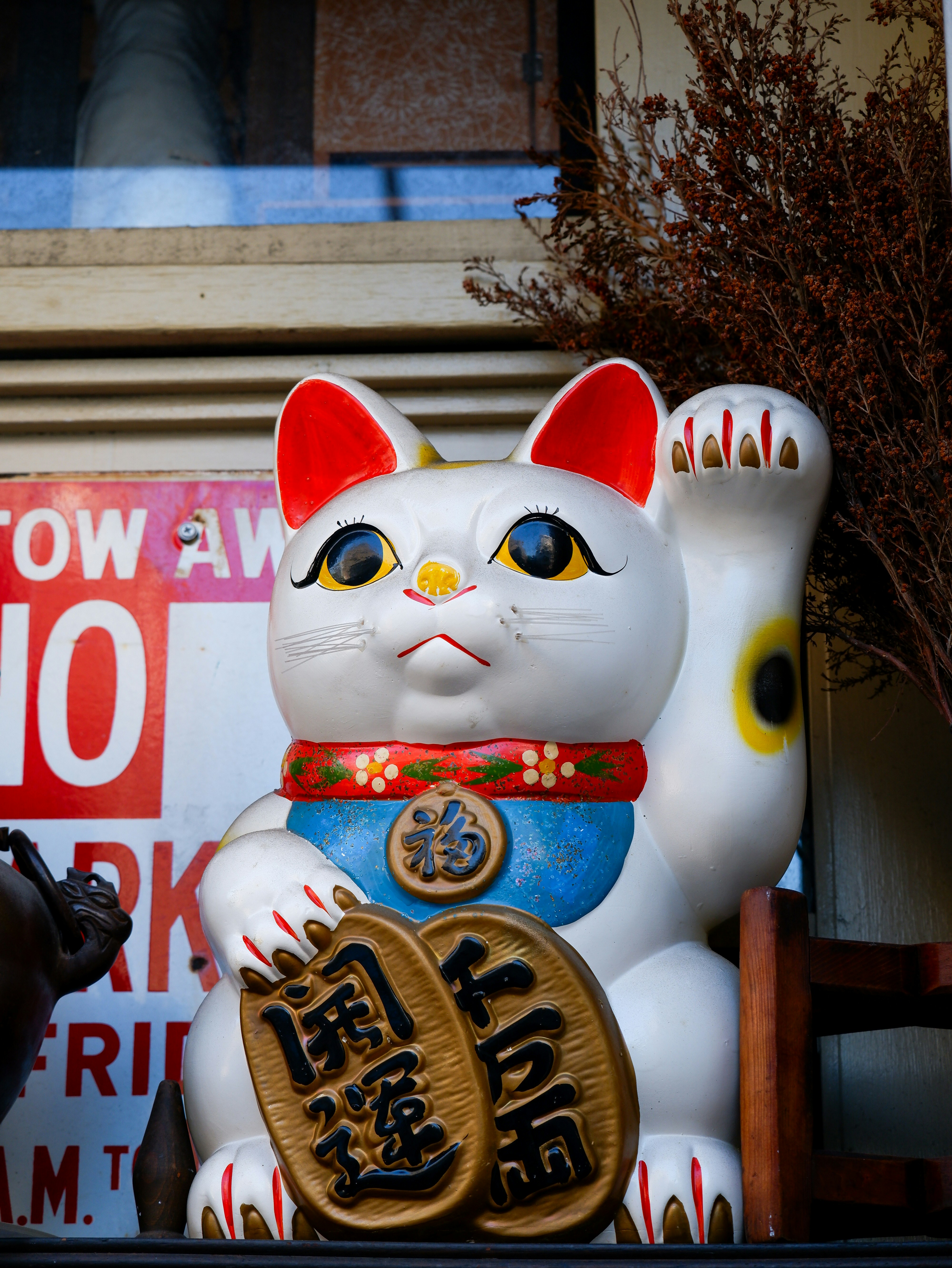 a white cat statue sitting on top of a shelf