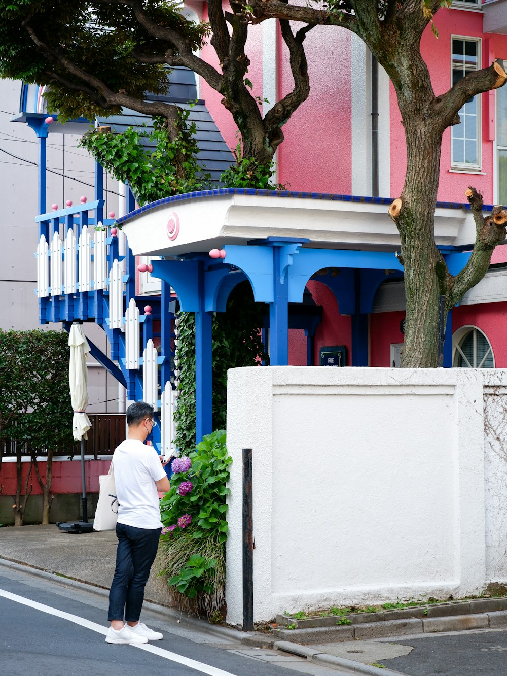 a man standing on the side of a road next to a tree