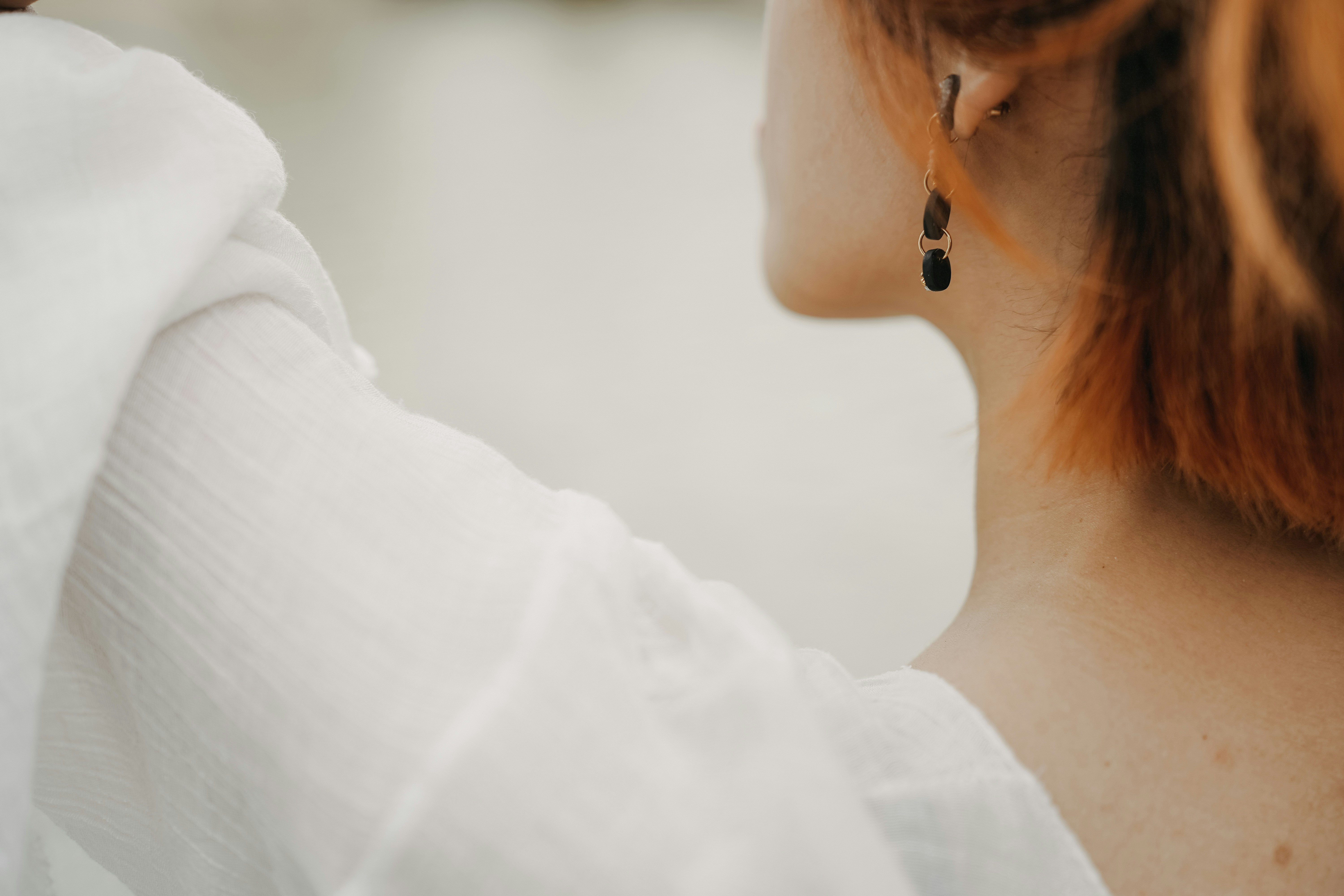 a close up of a person wearing a pair of earrings