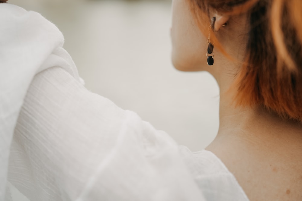 a close up of a person wearing a pair of earrings