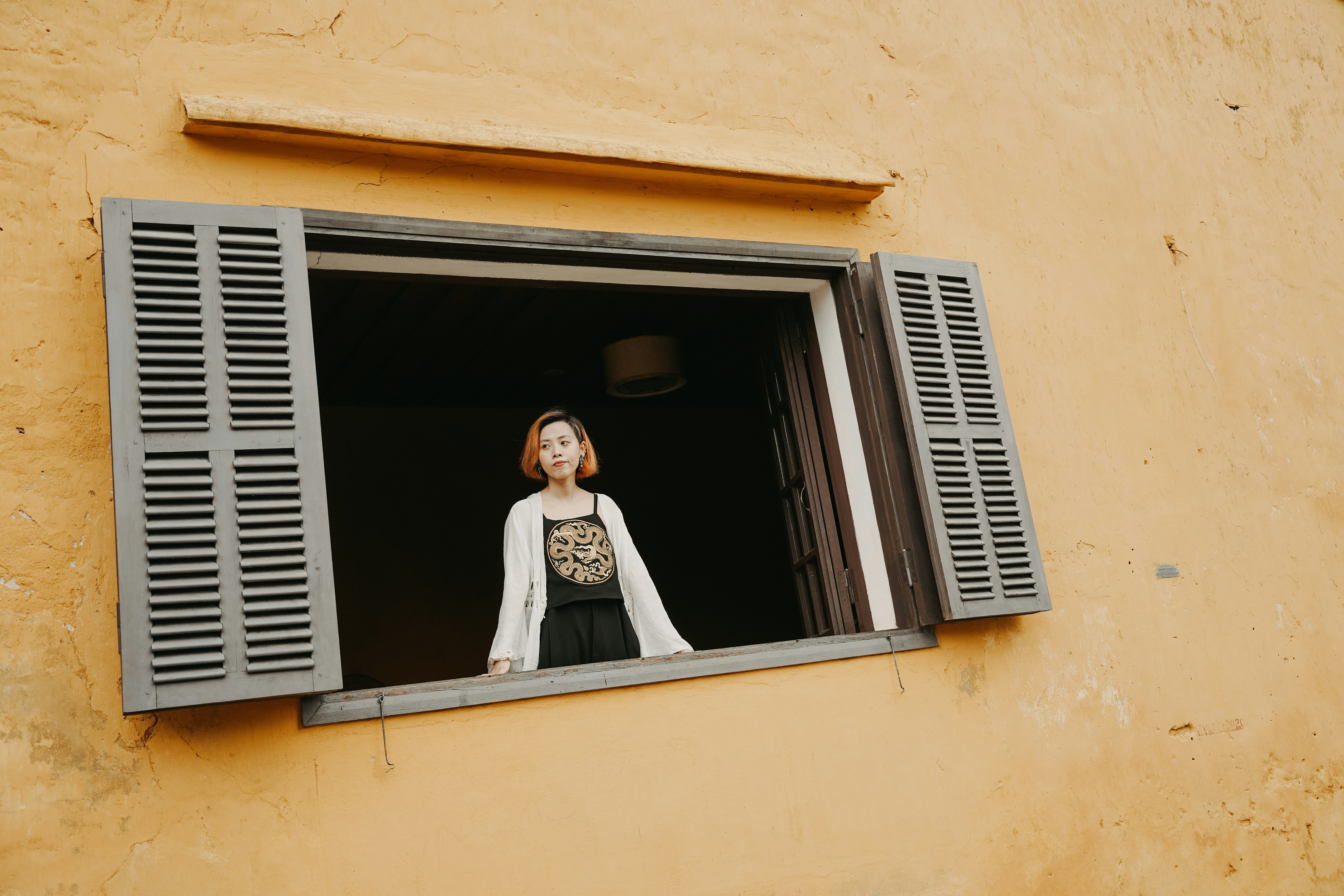a woman standing in a window of a building