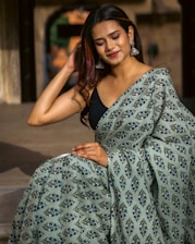 a woman wearing a green and black sari