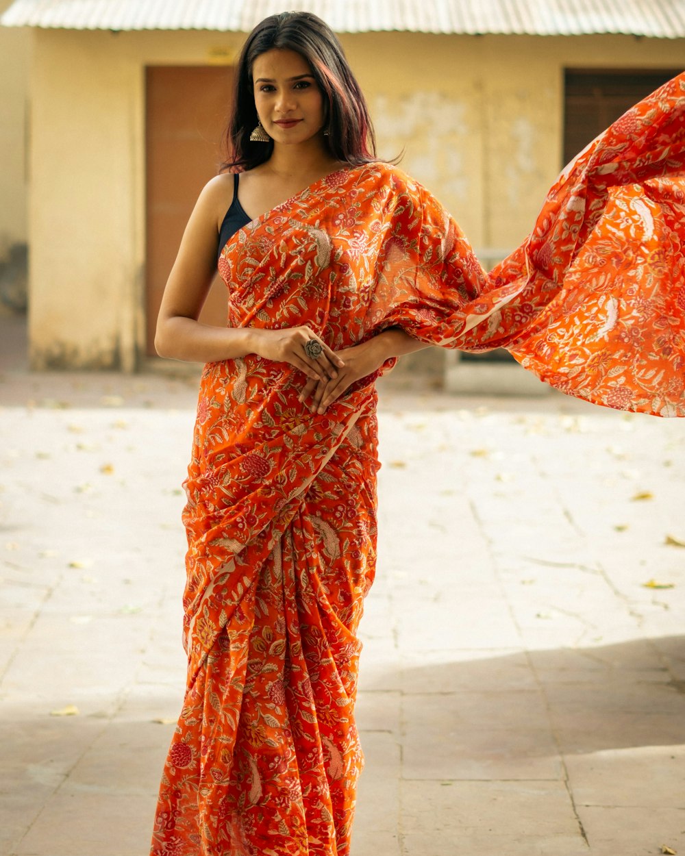 a woman in an orange and white sari