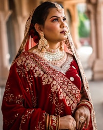 a woman in a red and gold bridal outfit