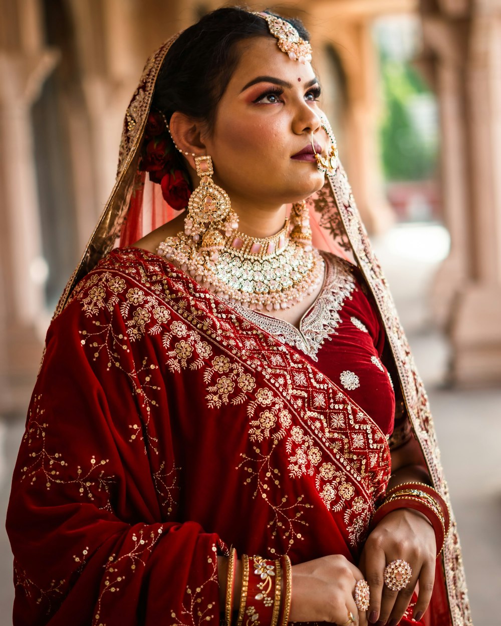 a woman in a red and gold bridal outfit