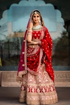 a woman in a red and gold bridal outfit