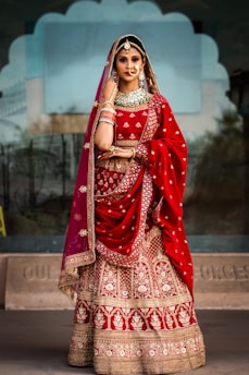 a woman in a red and gold bridal outfit