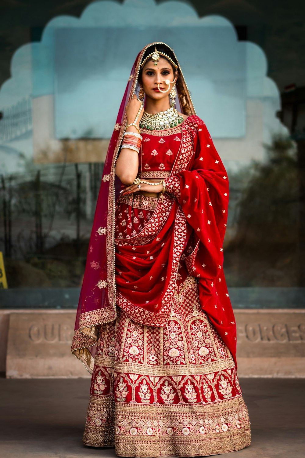 a woman in a red and gold bridal outfit