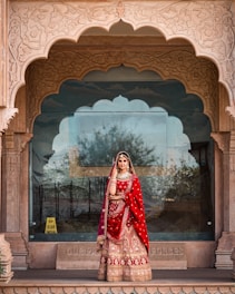 a woman in a red and gold bridal outfit
