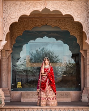 a woman in a red and gold bridal outfit