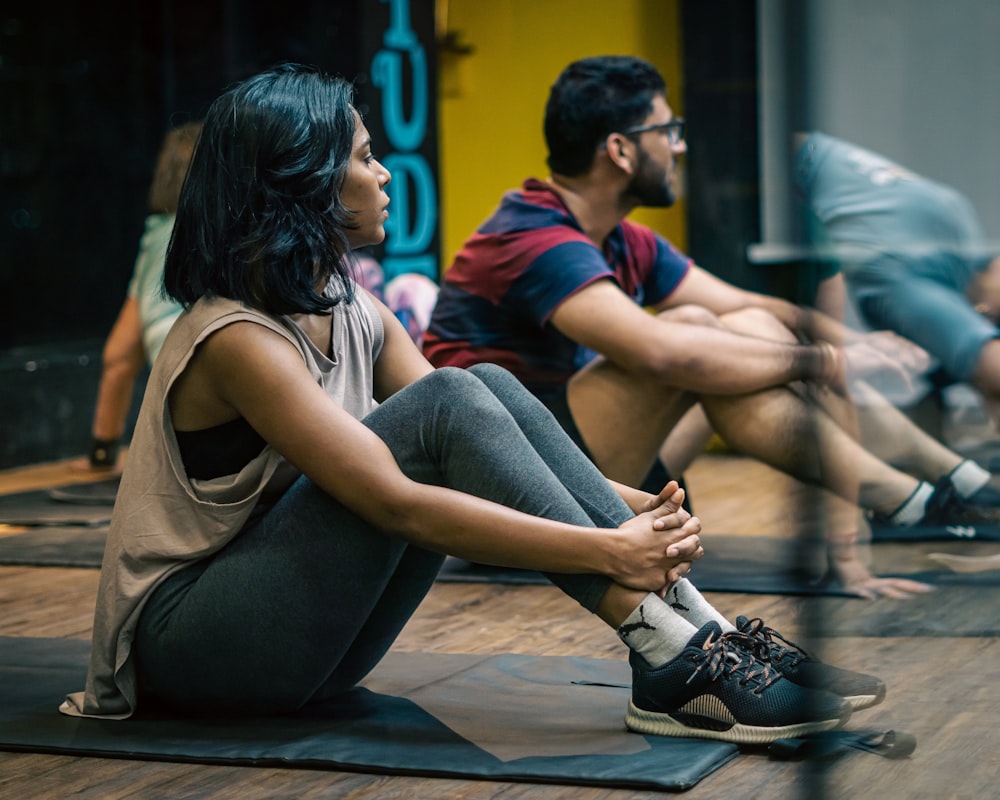 un groupe de personnes assises sur des tapis de yoga