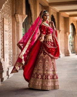 a woman in a red and gold bridal outfit