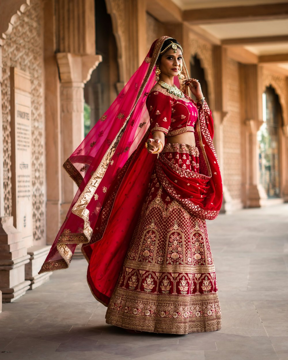 a woman in a red and gold bridal outfit