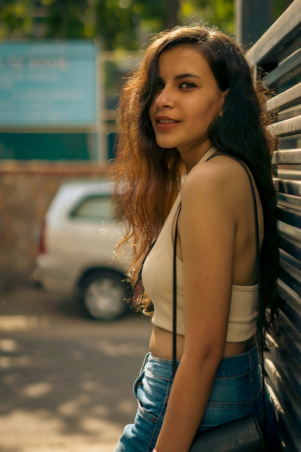 a woman leaning against a wall with her hand on her hip