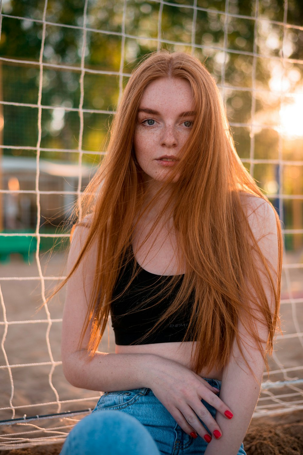 a woman with red hair sitting in front of a net