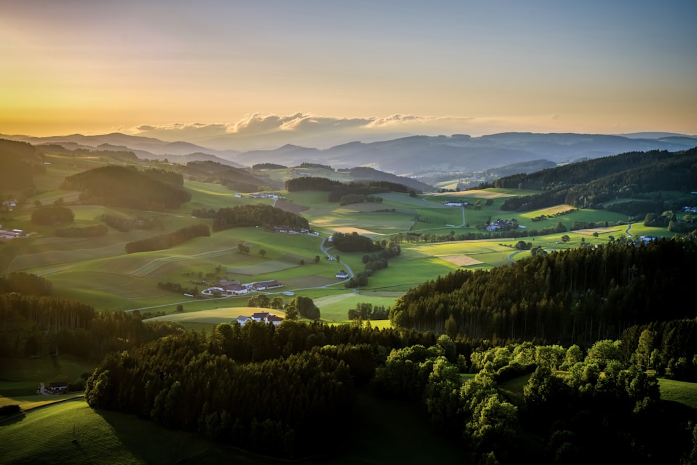 a scenic view of a valley with mountains in the background