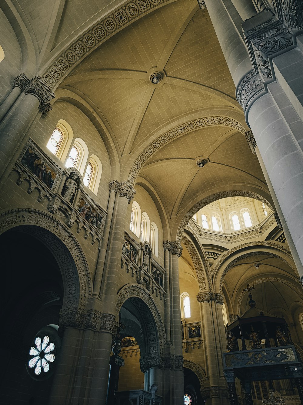 eine große Kathedrale mit hohen Gewölbedecken und einem Buntglasfenster