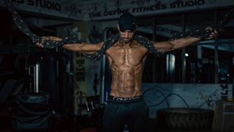 A determined man training in wrestling gear inside a gym with motivational posters on the walls.