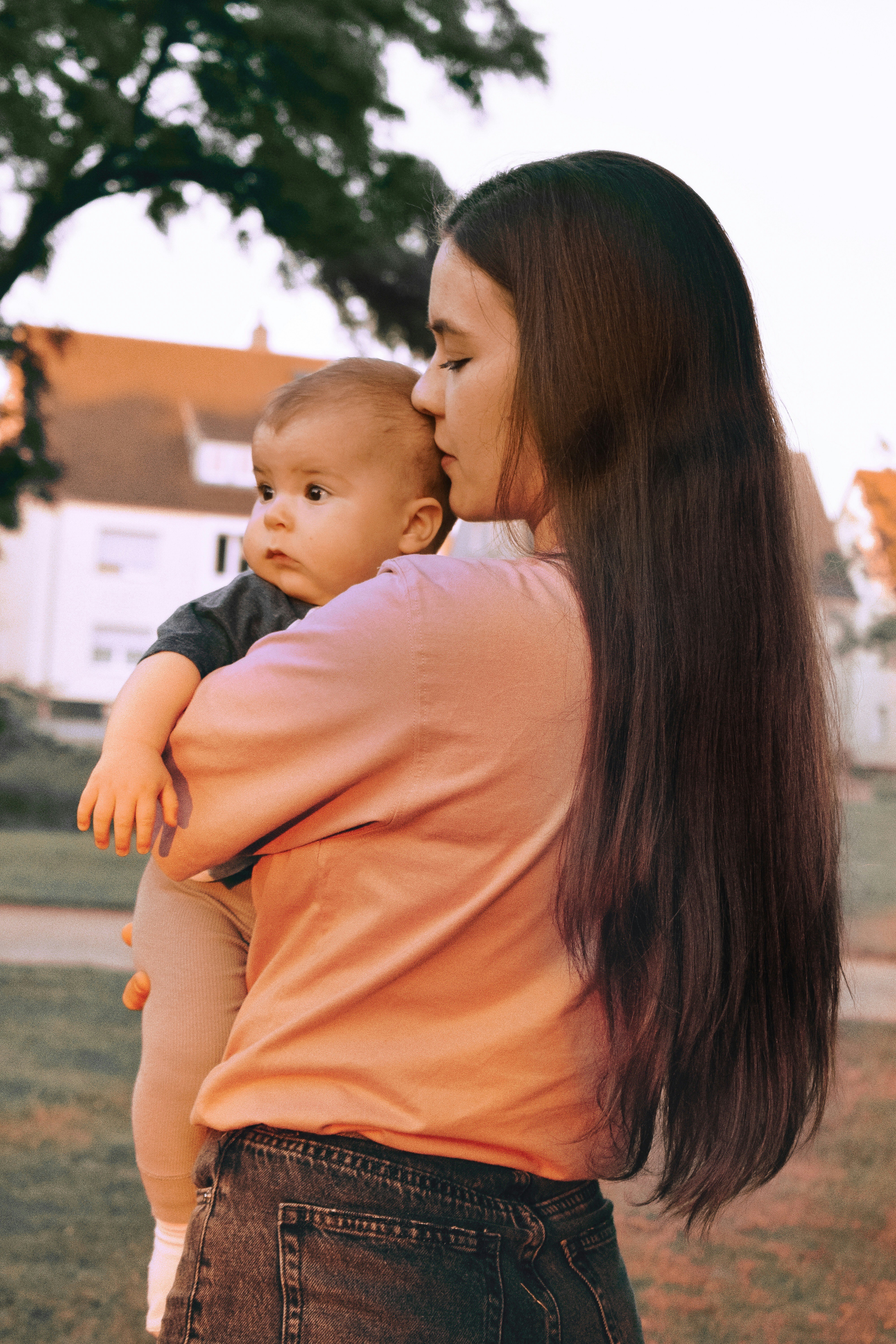 Seorang wanita menggendong bayi di pelukannya