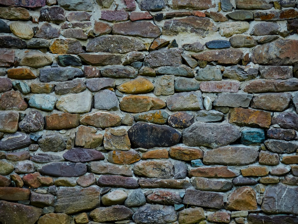 a stone wall made of various colored rocks