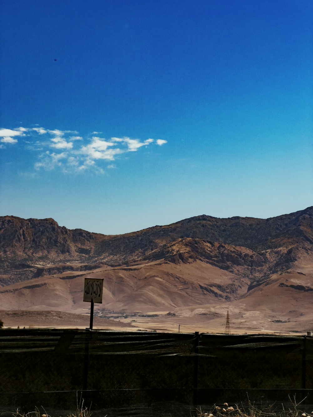 a view of a mountain range with a sign in the foreground