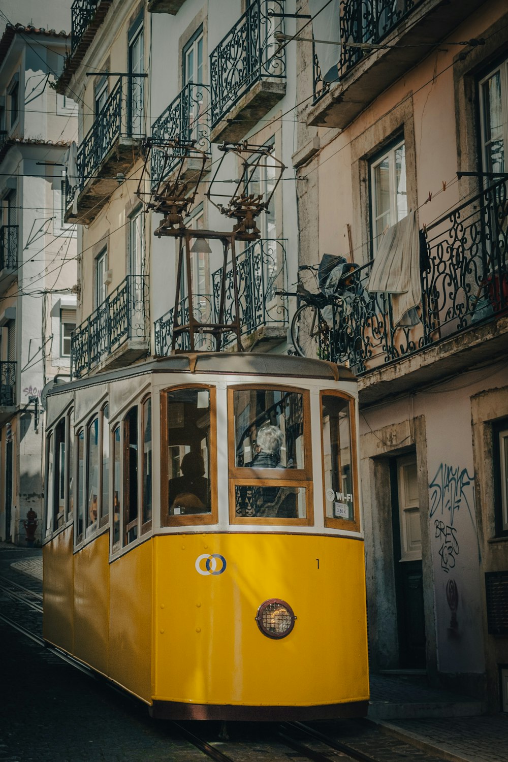 Un carrello giallo che viaggia lungo una strada accanto a edifici alti