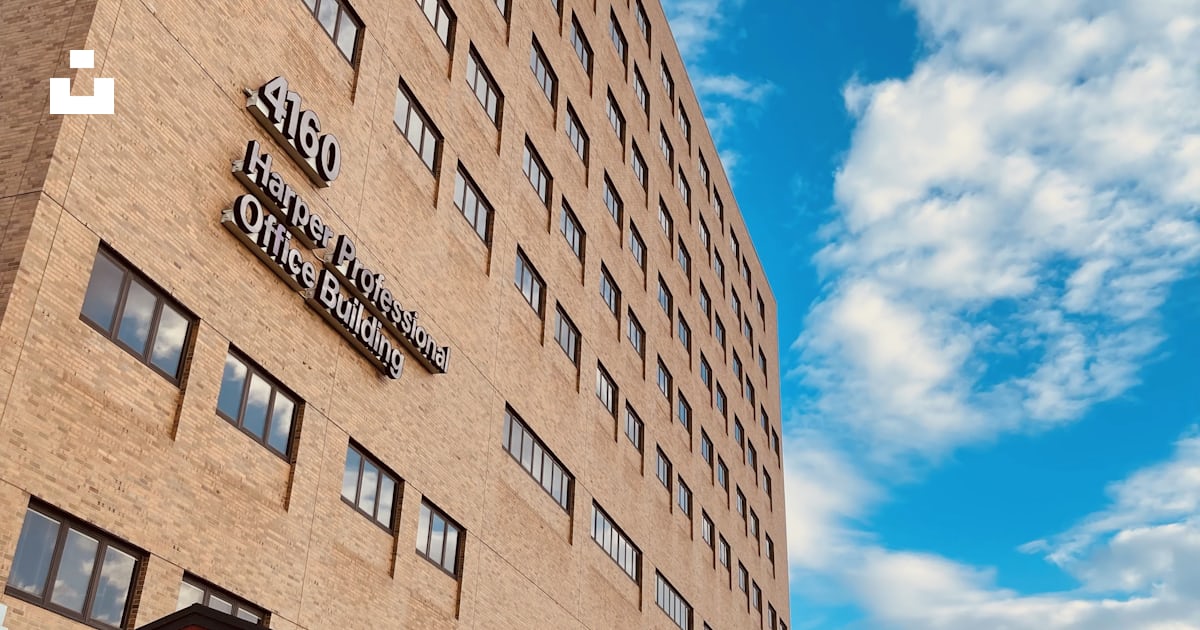 A tall brick building with a sky background photo Free Harper
